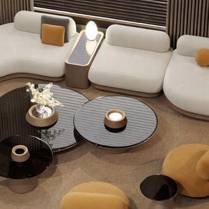 May include: An overhead view of a modern living room with white sofas, black glass coffee tables, and a mustard-colored armchair. The sofas have rounded edges and are arranged in a curved layout. Decorative pillows in gray and mustard add color.