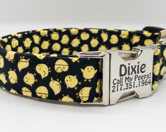 May include: Black dog collar with a yellow chick pattern and a silver buckle. The buckle is engraved with the name "Dixie", the text "Call My Peeps!" and the phone number "217.351.1964".