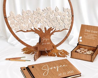 May include: Wooden guest book alternative with a tree design. The tree has leaf-shaped tags for guests to sign. Includes a wooden box, pens, and a matching guest book. The tree base and guest book are engraved with the name "Joyce" and the date "20.12.2025".