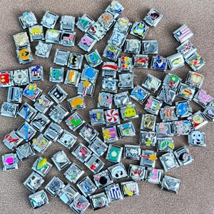 May include: A collection of colorful charm bracelets with various designs, including cartoon characters, animals, and words like "Family".