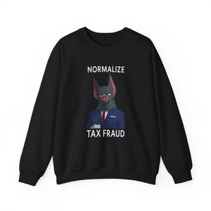 Könnte beinhalten: Schwarzes Sweatshirt mit einem fledermausartigen Charakter im Anzug, der den Text "NORMALIZE TAX FRAUD" zeigt. Die Fledermaus hat ein grünes Gesicht, rosa Ohren und trägt einen blauen Anzug und eine rote Krawatte.