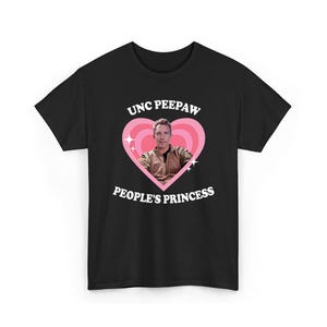 K&ouml;nnte beinhalten: Schwarzes T-Shirt mit einem rosa Herzdesign. Der Text "UNC PEEPAW" steht &uuml;ber dem Herzen und "PEOPLE'S PRINCESS" darunter. Im Inneren des Herzens befindet sich ein Foto eines Mannes. Zwei wei&szlig;e Sternausbr&uuml;che flankieren das Herz.
