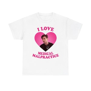 Puede incluir: Camiseta blanca con un corazón rosa que contiene un hombre y las palabras "I LOVE MEDICAL MALPRACTICE" en rosa. Un diseño casual y humorístico.
