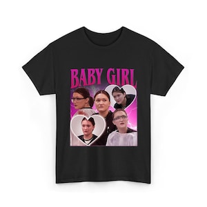Könnte beinhalten: Schwarzes T-Shirt mit einem Grafikdesign. Das Design zeigt den Text "BABY GIRL" in Rosa, mit Bildern von Frauen in herzförmigen Rahmen, vor einem rosa-violetten Blitzhintergrund.