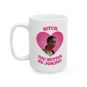 Può includere: Tazza in ceramica bianca con un grande cuore rosa. Il cuore contiene l'immagine di una donna e le parole "BITCH, YOU BETTER BE JOKING" in rosa. La tazza ha un grande manico.