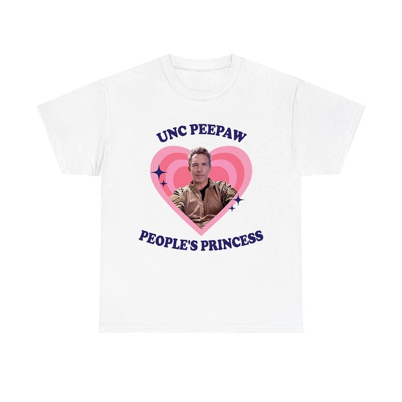 K&ouml;nnte beinhalten: Wei&szlig;es T-Shirt mit einem rosa Herzdesign. Der Text "UNC PEEPAW" steht &uuml;ber dem Herzen und "PEOPLE'S PRINCESS" darunter. Ein Foto eines Mannes befindet sich im Herzen. Das T-Shirt hat einen Rundhalsausschnitt.