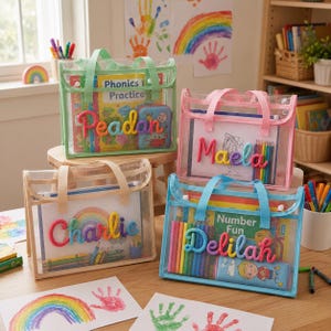 May include: Four rectangular clear mesh tote bags with colored trim and handles. Each bag features a personalized name in colorful yarn lettering on the front. The bags contain various books, coloring pages, and colored pencils for activities.
