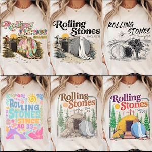 May include: A collection of six beige t-shirts featuring the text "Rolling Stones Since AD 33" with various graphic designs. The designs include images of a tomb, cross, and sun.