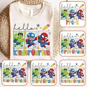 May include: Off-white t-shirt with a colourful graphic featuring the word "hello" and illustrations of Hulk, Captain America, and Spider-Man. The shirt is designed for Kindergarten, with additional designs for Pre-K, and grades 1-4.