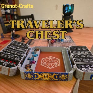Op de afbeelding: Een grijze en beige Traveler's Chest voor tabletop gaming. De kist is open en onthult dobbelstenen en een rode kaart met een wit 20-zijdige dobbelsteensymbool. De kist heeft compartimenten voor dobbelstenen en spelonderdelen. De tekst "TRAVELER'S CHEST" wordt weergegeven.