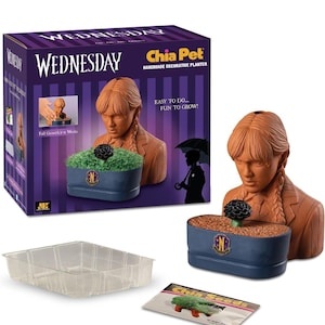 May include: A Wednesday Addams Chia Pet handmade decorative planter featuring a terracotta bust of a character with braided hair, a dark blue oval base with a gold N emblem, a clear plastic drip tray, and a packet of Chia seeds in a purple box.