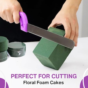 Op de afbeelding: Een mes met een paarse handgreep snijdt een groene bloemschuimtaart. De tekst "PERFECT FOR CUTTING Floral Foam Cakes" staat onder de afbeelding.