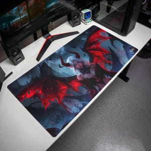 May include: A rectangular desk mat featuring a digital illustration of a pale-skinned character with white hair, horns, and large, vibrant red and black wings. The background depicts a dark, atmospheric landscape with silhouettes of flying bats.