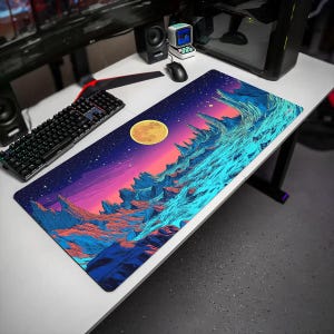 May include: A rectangular desk mat featuring a vibrant, colorful illustration of a rocky alien landscape under a starry night sky with a large yellow moon. The artwork displays sharp mountain peaks in shades of blue, orange, and pink.