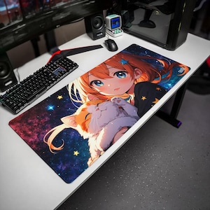 May include: A rectangular desk mat featuring an anime-style illustration of a person with orange hair and a white and orange cat against a dark blue galaxy background with yellow stars. The mat is positioned on a white desk next to a black keyboard.