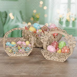 Może przedstawiać: Trzy drewniane koszyki wielkanocne wypełnione kolorowymi, zdobionymi jajkami. Koszyki mają skomplikowane wycinane wzory i uchwyty. Jajka są pomalowane różnymi wzorami i kolorami, w tym niebieskim, różowym, żółtym i czerwonym.