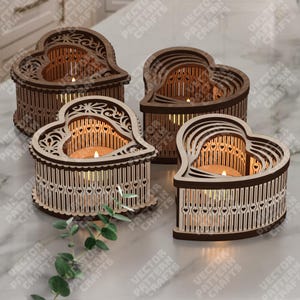 May include: Four heart-shaped wooden candle holders with detailed cut-out patterns. Each holder has a different wood tone and holds a lit candle. The holders are arranged on a marble surface, creating a warm, inviting atmosphere.
