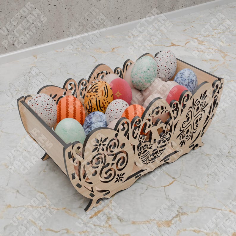 May include: A wooden Easter basket filled with decorative eggs. The basket has a cut-out design and is filled with eggs of various colors and patterns. The basket is made of light-colored wood and sits on a marble surface.
