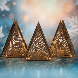 Może przedstawiać: Trzy drewniane, piramidalne dekoracje świąteczne z misternymi wycinanymi wzorami. Każda piramida ma inną świąteczną sylwetkę, w tym Świętego Mikołaja i choinkę. Ciepłe, złoto-brązowe drewno kontrastuje z niebieskim tłem.