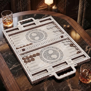 May include: A wooden backgammon set with a light wood finish, featuring intricate Celtic knot designs and a handle. The set includes brown and silver game pieces, dice, and two glasses of amber liquid. The game board is open, ready for play.