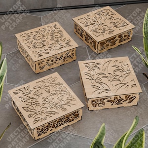 Peut inclure: Quatre boîtes en bois avec des motifs floraux complexes découpés dans le bois. Les boîtes sont toutes de la même taille et de la même forme, mais chacune a un motif floral différent.