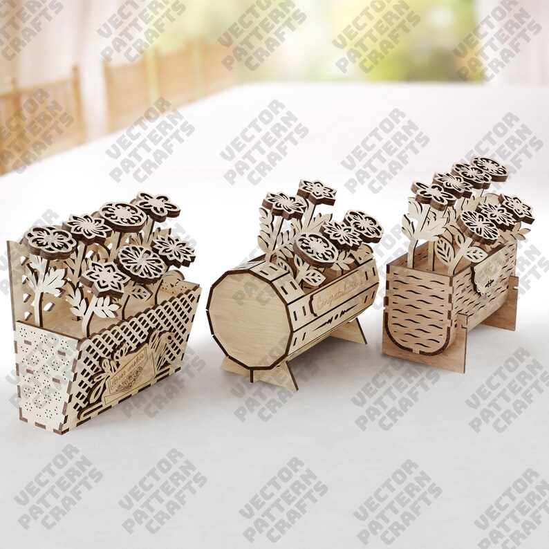 May include: Three wooden flower boxes with laser-cut floral designs. The boxes are in different shapes: a basket, a barrel, and a rectangular container. Each box holds wooden flowers, creating a decorative display. The boxes are made of light-colored wood.