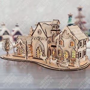 May include: A wooden Christmas village scene with intricate cut-out details. The scene includes buildings, a tree, reindeer pulling a sleigh, and a snowman. The buildings have illuminated windows, creating a warm glow. The base has the text "VECTOR PATTERN CRAFTS".