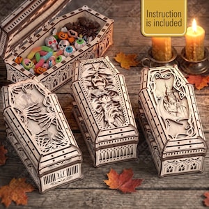 May include: Three laser-cut wooden coffin-shaped boxes with intricate gothic carvings, including a skeleton design and a castle scene. One open box contains colourful candy. A yellow sign states, "Instruction is included."