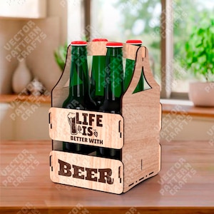 Op de afbeelding: Een houten bierkrat met zes groene bierflessen met rode doppen. De krat heeft de gegraveerde tekst "LIFE IS BETTER WITH BEER". De krat staat op een houten oppervlak. De flessen zijn ongeveer 20 cm hoog.