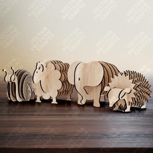 Puede incluir: Figuras de animales de madera, incluyendo un caracol, una oveja, un elefante y un erizo. Las figuras est&aacute;n hechas de madera clara y tienen un dise&ntilde;o en capas. El caracol tiene un patr&oacute;n detallado en su caparaz&oacute;n.