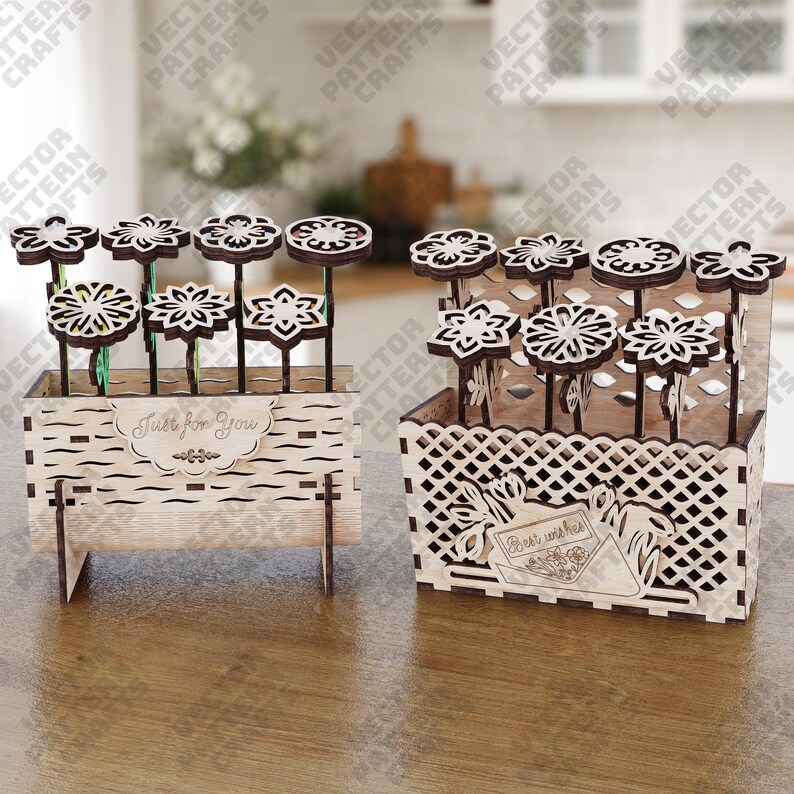 May include: Two wooden flower arrangements. One is a rectangular box with the text "Just for You". The other is a basket with the text "Best wishes". Both contain laser-cut wooden flowers with dark brown stems and white flower heads.