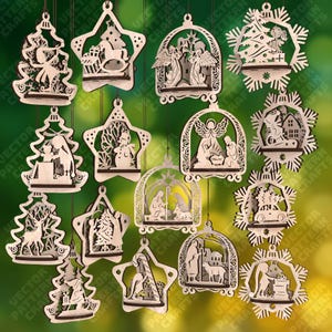May include: A collection of laser-cut wooden Christmas ornaments in various shapes, including stars, trees, and snowflakes. The ornaments feature festive scenes such as angels, nativity scenes, and winter landscapes. Each ornament is suspended by a string.