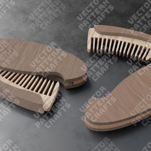 May include: A wooden comb with a folding design. The comb is made of light brown wood and has a natural wood grain. The comb is closed and folded in half, with the teeth of the comb visible.