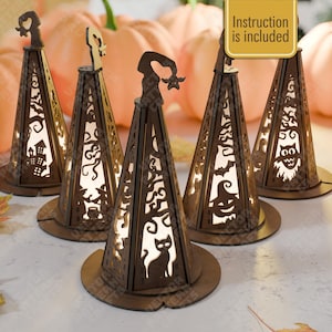 May include: Five conical wooden lanterns featuring intricate laser-cut Halloween designs including a cat, a witch, a pumpkin, an owl, and a haunted house. Each dark brown wooden structure has a pointed top and a circular base. Instruction is included.