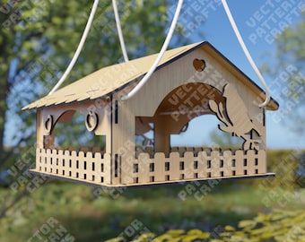 May include: A wooden bird feeder shaped like a house with a small fence around the bottom. The feeder is hanging from a white rope and has a bird silhouette on the front.