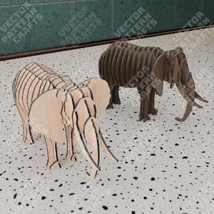 May include: Two wooden elephant models, one light brown and one dark brown, are made of layered wood and stand on a white tiled surface.
