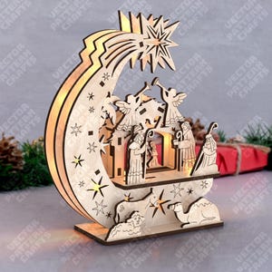 Op de afbeelding: Een houten kerststal met een halve maan en ster ontwerp. De scène omvat engelen, de drie wijzen, een kameel en een schaap. Het ontwerp is verlicht met warm licht.