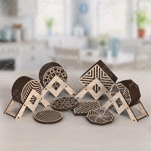 Puede incluir: Una colección de posavasos y soportes de madera cortados con láser en varias formas y patrones geométricos. Los posavasos presentan diseños como círculos, líneas y formas geométricas. Los soportes están hechos de madera clara y marrón oscuro. El texto "VECTOR PATTERN CRAFTS" es visible.