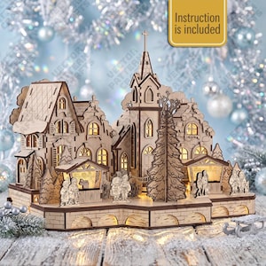 May include: A laser-cut wooden Christmas village display featuring a church with a steeple, multiple houses, and small figures of people. The structure includes illuminated windows and a sign that reads "Instruction is included" in the upper right corner.
