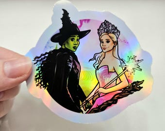 Pegatina inspirada en Elphaba y Glinda de Wicked, con Cynthia Erivo y Ariana Grande.