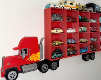 May include: A red truck-shaped shelf unit with multiple compartments, filled with various toy cars. The truck features the number "95" and a lightning bolt graphic. The shelf is mounted on a white wall, creating a playful display for toy car collections.