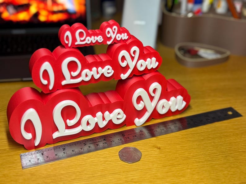 3D printed ‘I Love You’ signs in mini (8cm), regular (16cm), and giant (24cm) sizes. Ideal for Valentine’s Day gifts, romantic decor, anniversaries, or special occasions. Features bold red hearts with white protruding letters for a unique decoration.