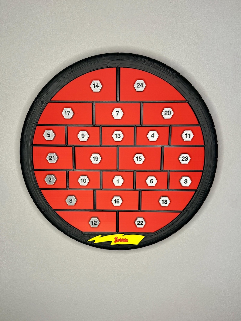 May include: A red and black advent calendar with 24 numbered compartments. The calendar is circular, with a black tire-like frame. The compartments are red with white numbers. The word "Bobble" is printed on a yellow lightning bolt.