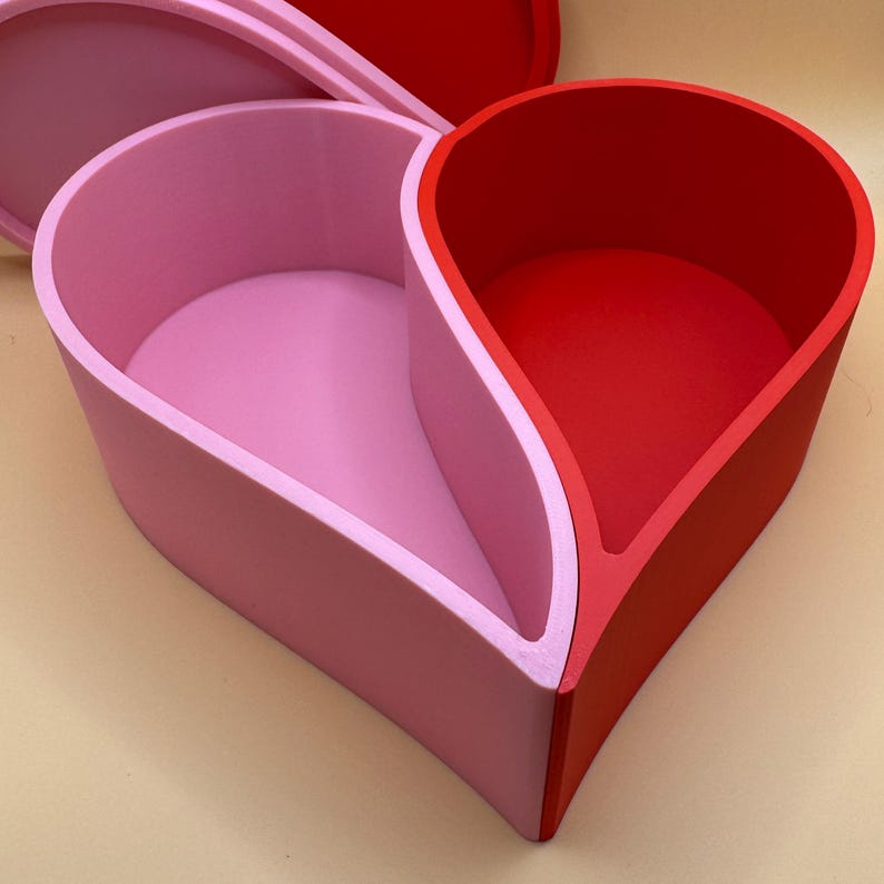 A large 3D-printed heart-shaped box with sturdy, smooth-edged walls, featuring vibrant red and pastel pink tones. Ideal for keepsakes, jewellery, or gifts, this durable design is crafted from eco-friendly PLA with a bold, modern aesthetic.