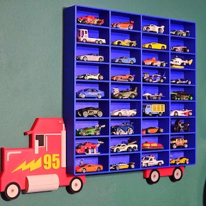 Blue toy car shelf inspired by Lightning McQueen, featuring 36-144 compartments for storing toy cars or Hot Wheels. A bold red truck design with yellow lightning bolt and the number 95 on the cab adds a fun, themed touch to any kid’s room
