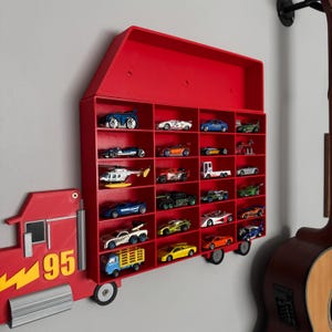 May include: Red toy truck wall shelf with a red roof and 24 slots for toy cars. The truck has the number 95 on the side.