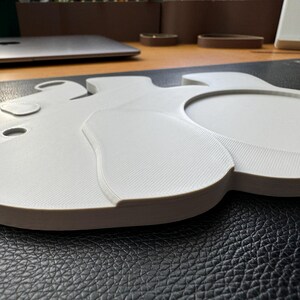 Side view of the 3D-printed elephant coaster showing the layered texture and raised design of the ear and body.