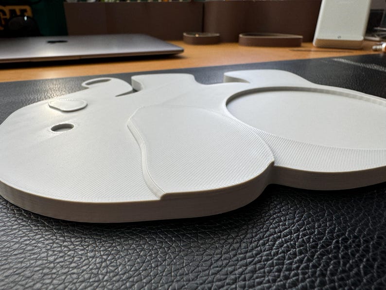 Side view of the 3D-printed elephant coaster showing the layered texture and raised design of the ear and body.