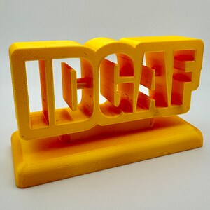Bright yellow 3D printed 'IDGAF' sign, perfect for desk, shelf, or trophy display, showcasing bold and playful lettering.