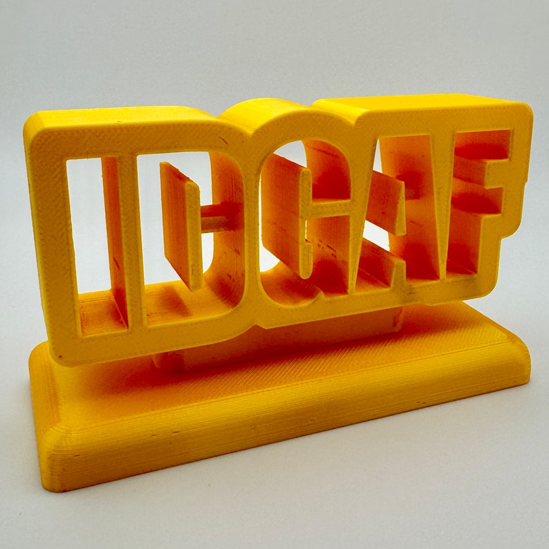 Bright yellow 3D printed 'IDGAF' sign, perfect for desk, shelf, or trophy display, showcasing bold and playful lettering.